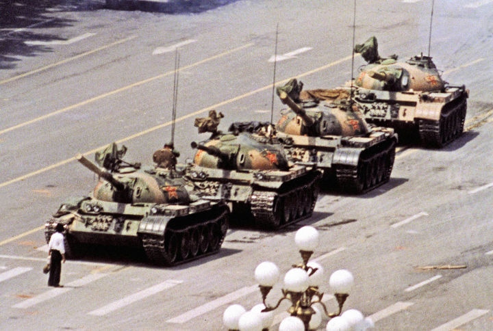 Famous picture of the man standing in front of a column of tanks.